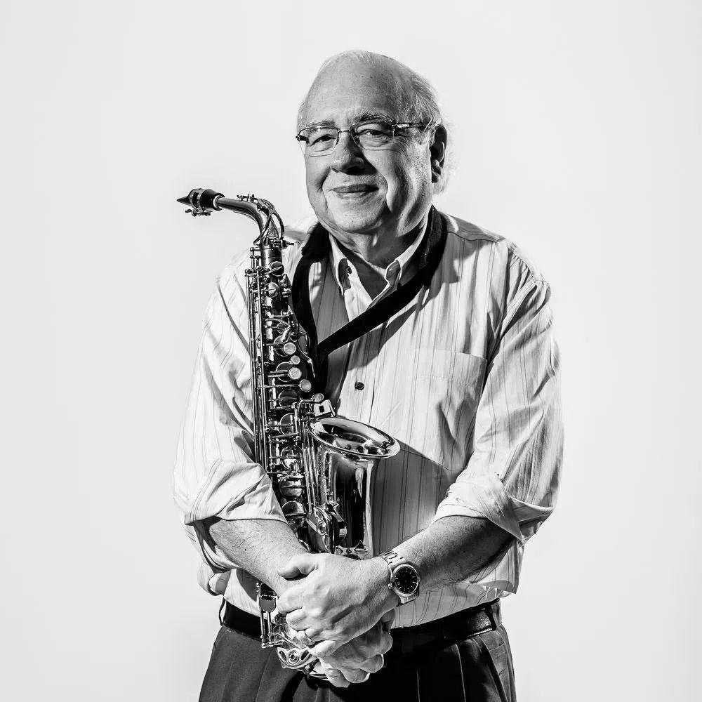 Luis Vernando Verissimo segurando um saxofone numa foto em preto e branco